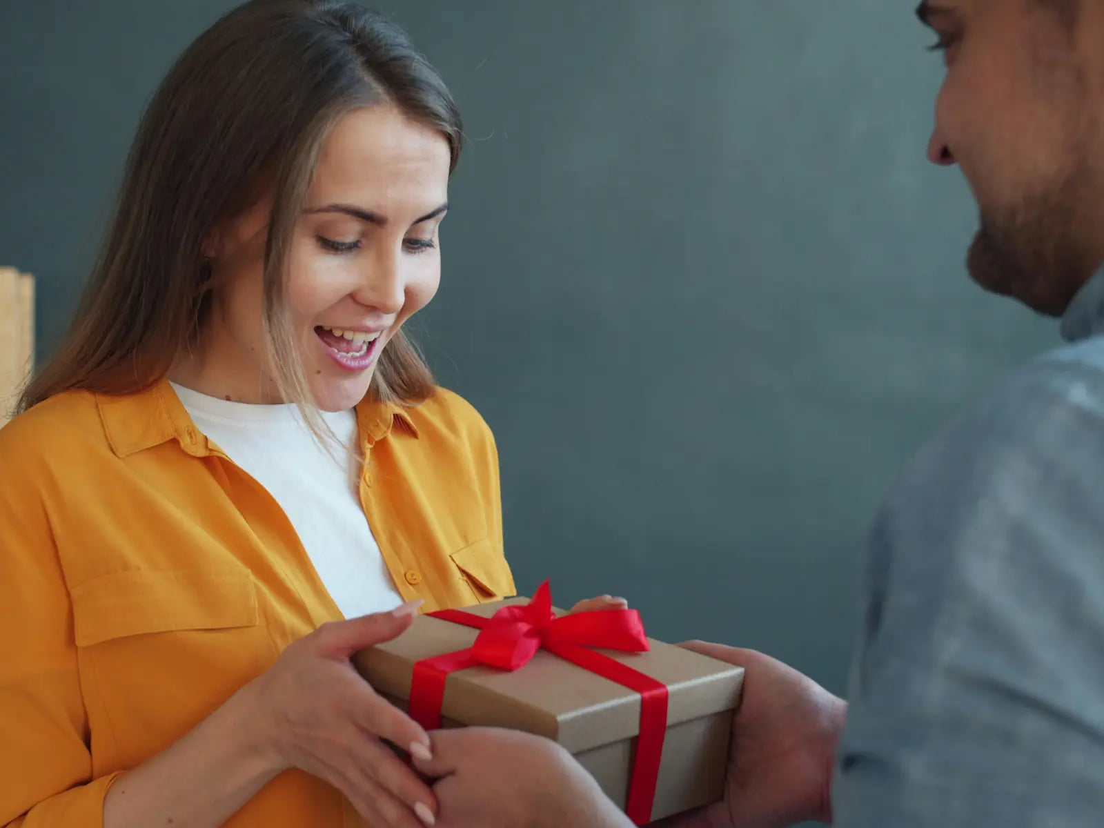 A person experiencing a genuine emotional reaction while receiving a gift — the psychology behind memorable moments and what makes a gift impossible to forget